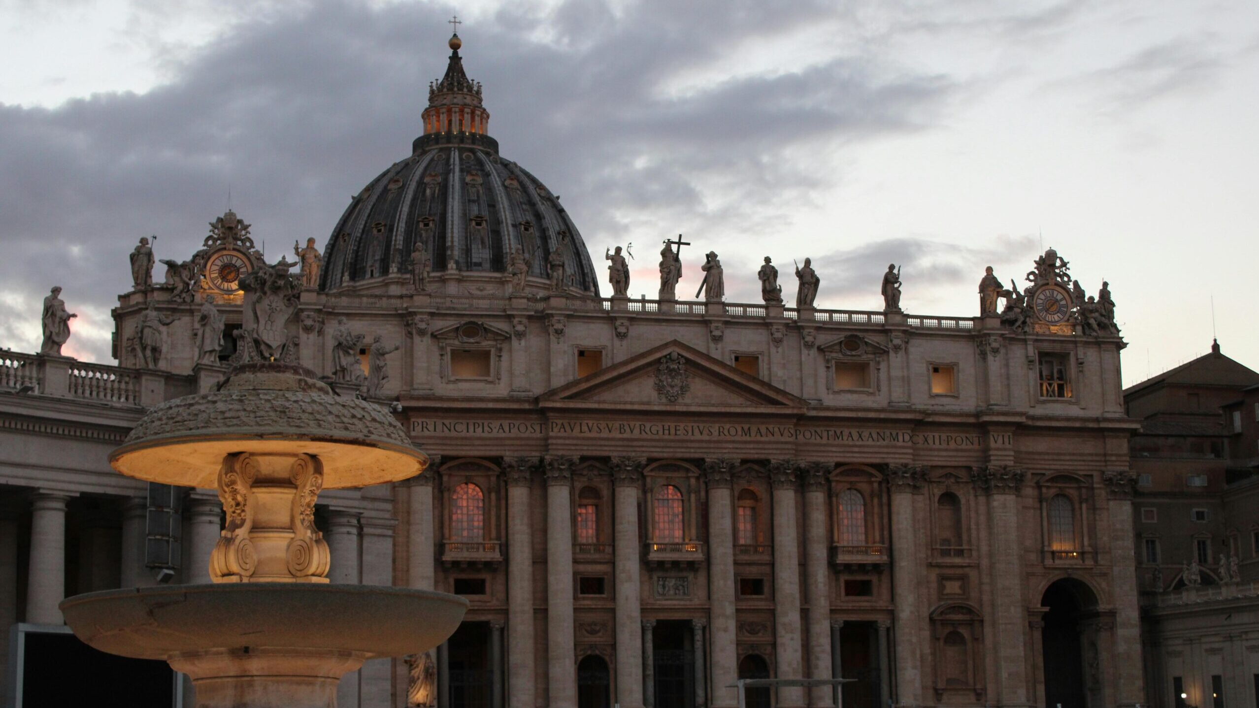 Magnificent view of St. Peter's Basilica at twilight with a fountain in the foreground, Vatican City.