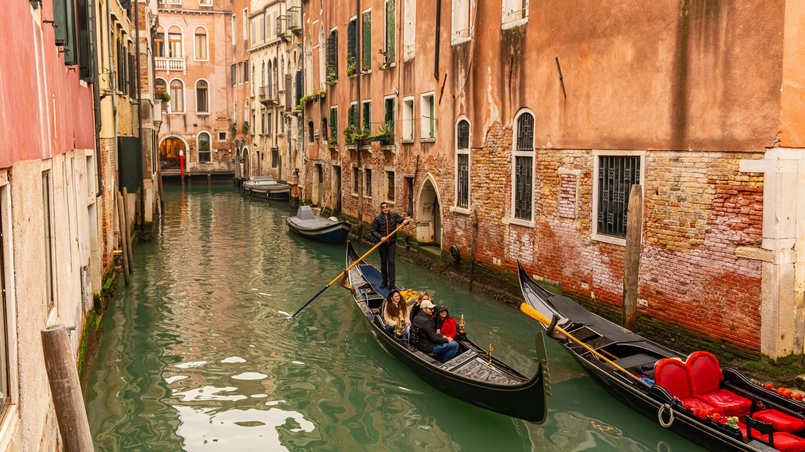 Gondolas on a charming Venetian canal surrounded by historic architecture in Venice, Italy.