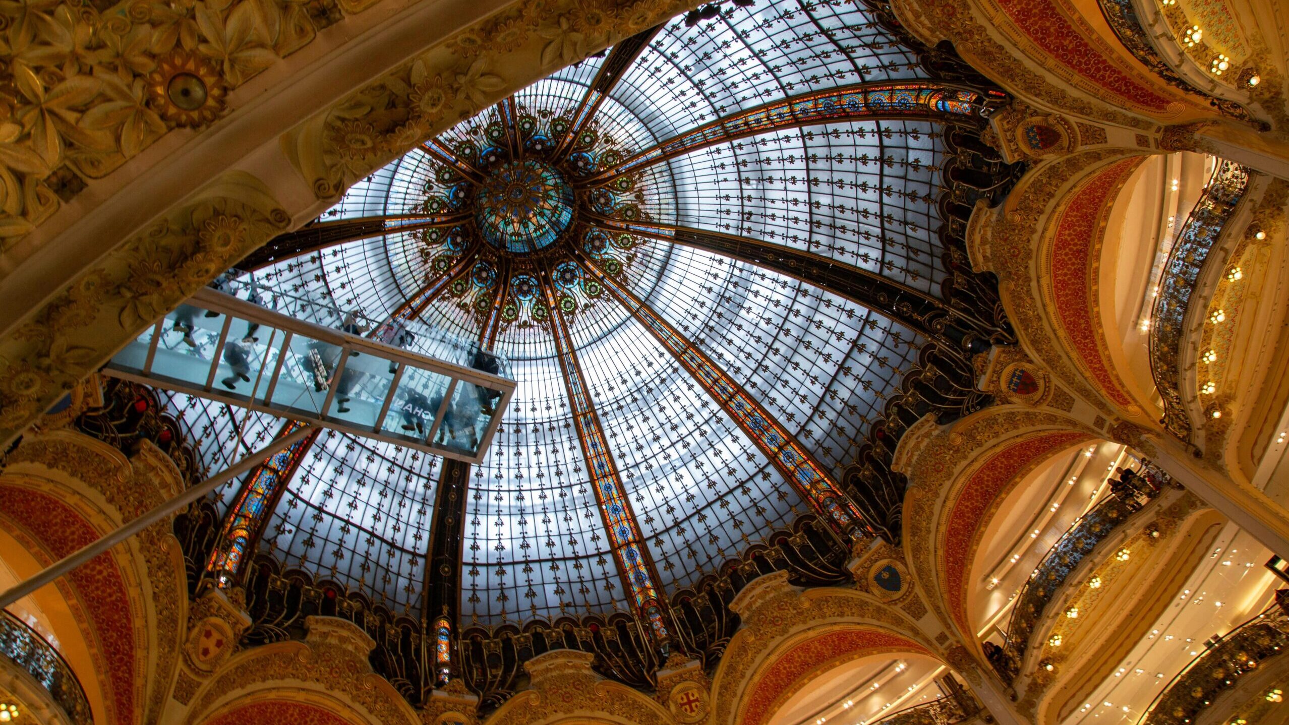 Explore the stunning dome interior of Galeries Lafayette in Paris showcasing intricate architecture.