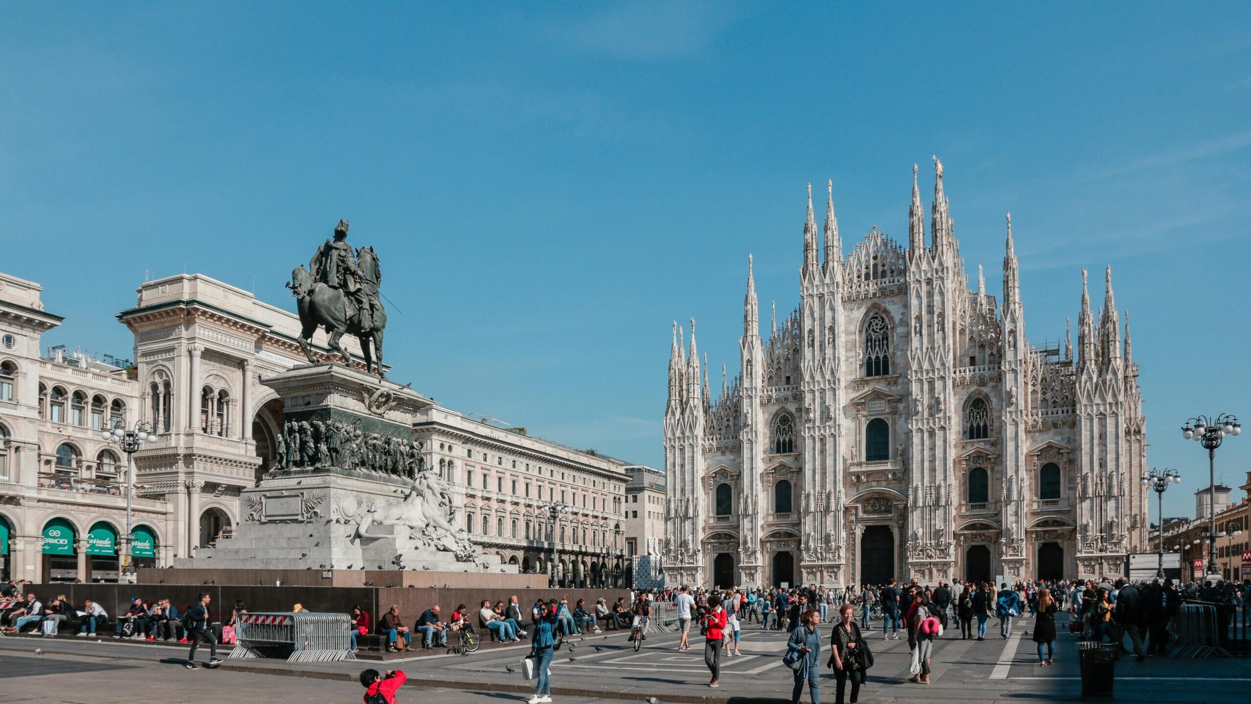 Capture of Milan's iconic Duomo di Milano with vibrant city life in Piazza del Duomo.