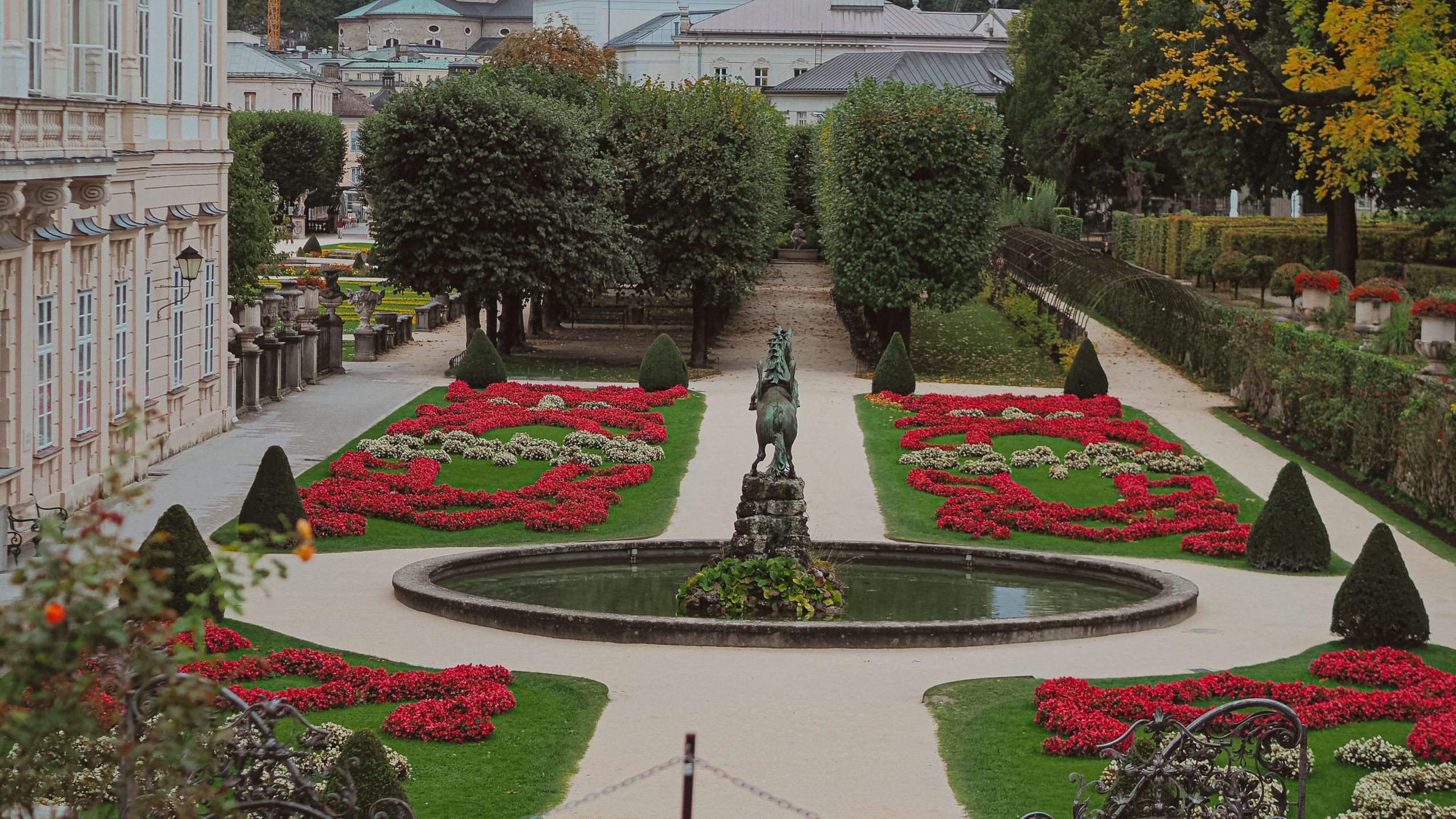 Beautiful view of Mirabell Gardens with Salzburg Cathedral in the background, capturing the vibrant autumn scenery.