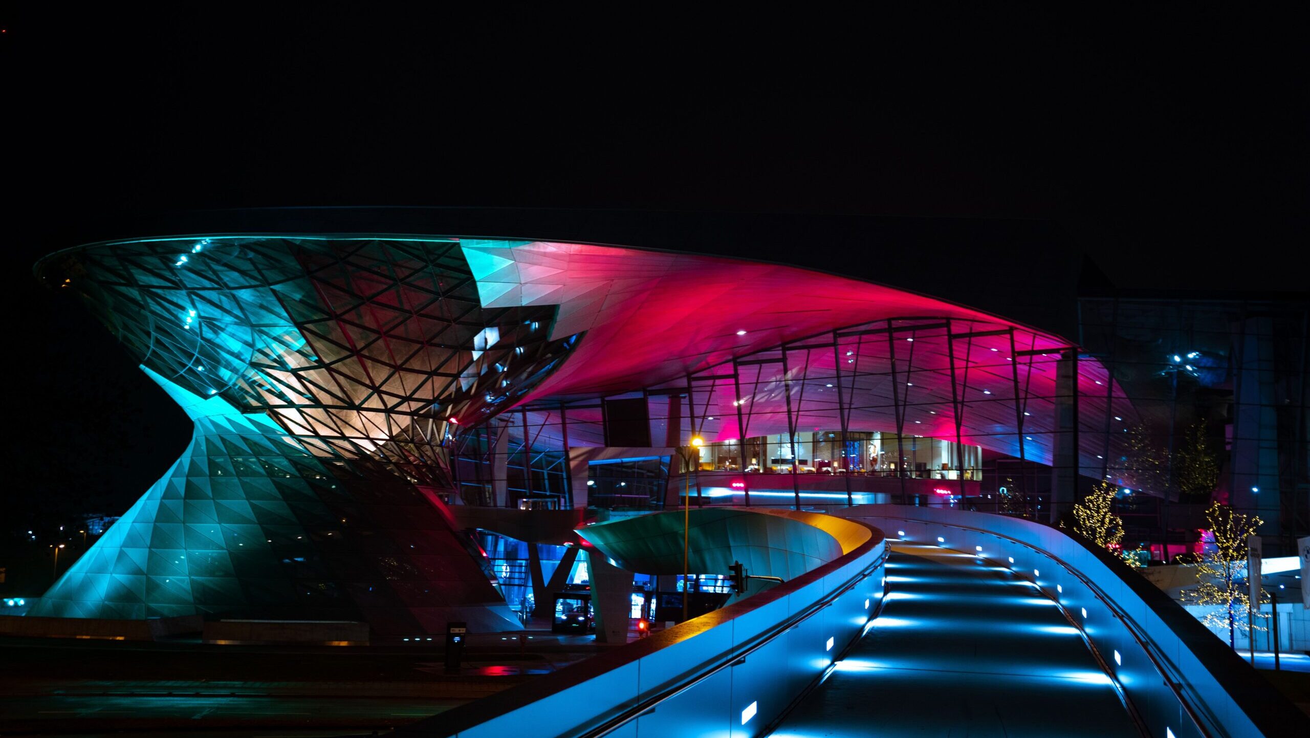 A stunning night view of BMW Welt in Munich, showcasing its modern illuminated architecture.
