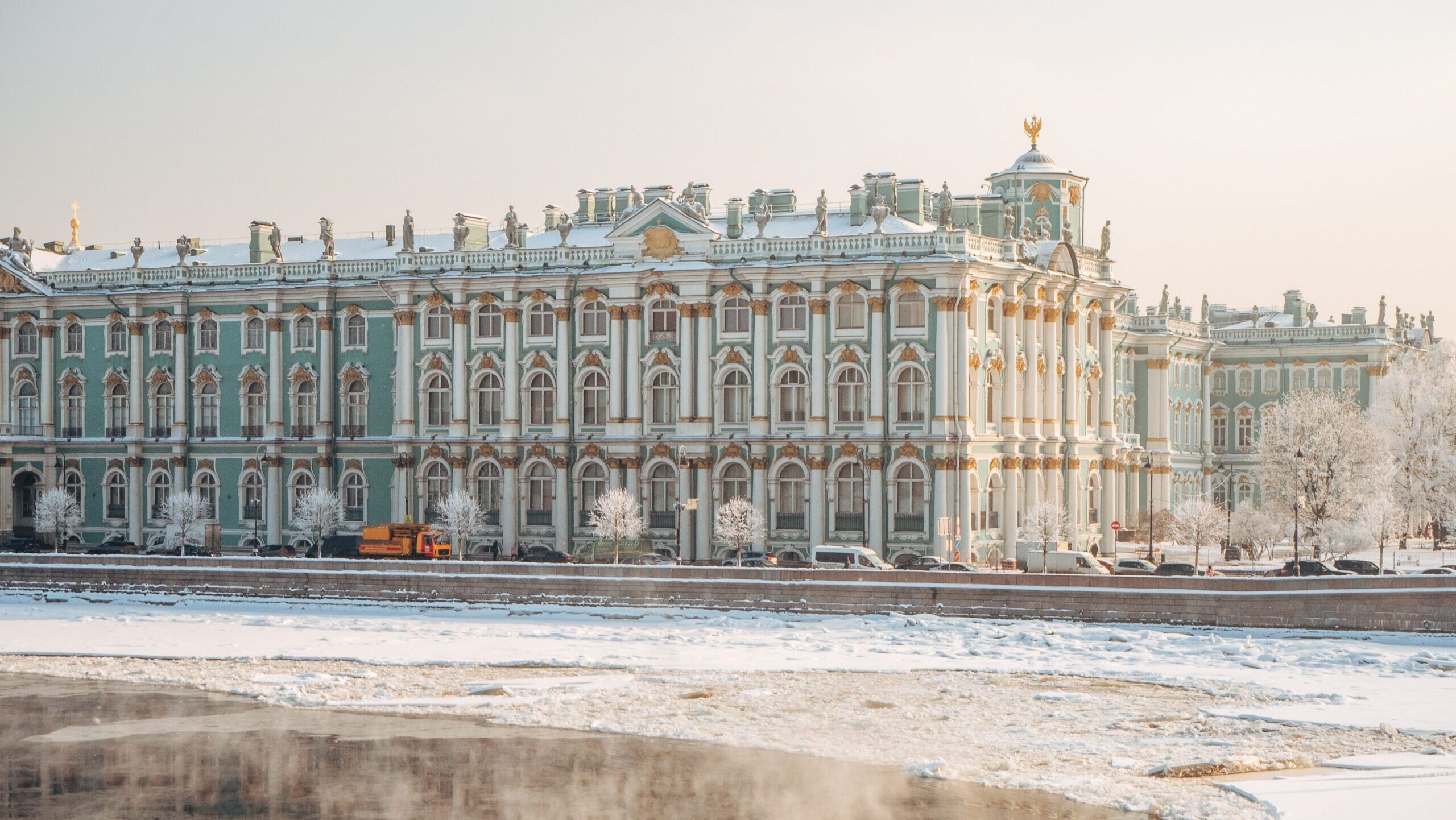 Snow-covered Hermitage Museum with icy Neva River in winter, St. Petersburg.