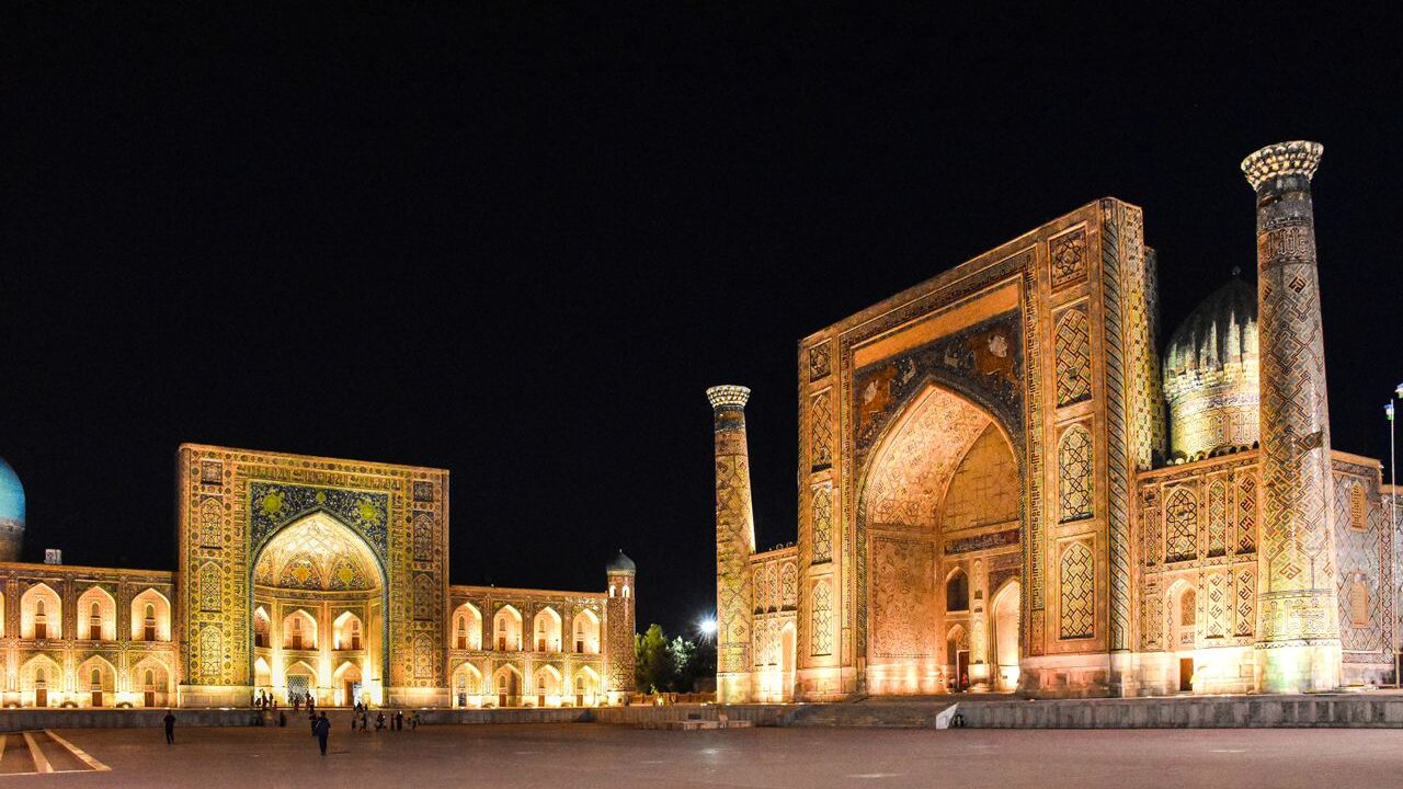 Illuminated architecture of Registan Square in Samarkand under the night sky.