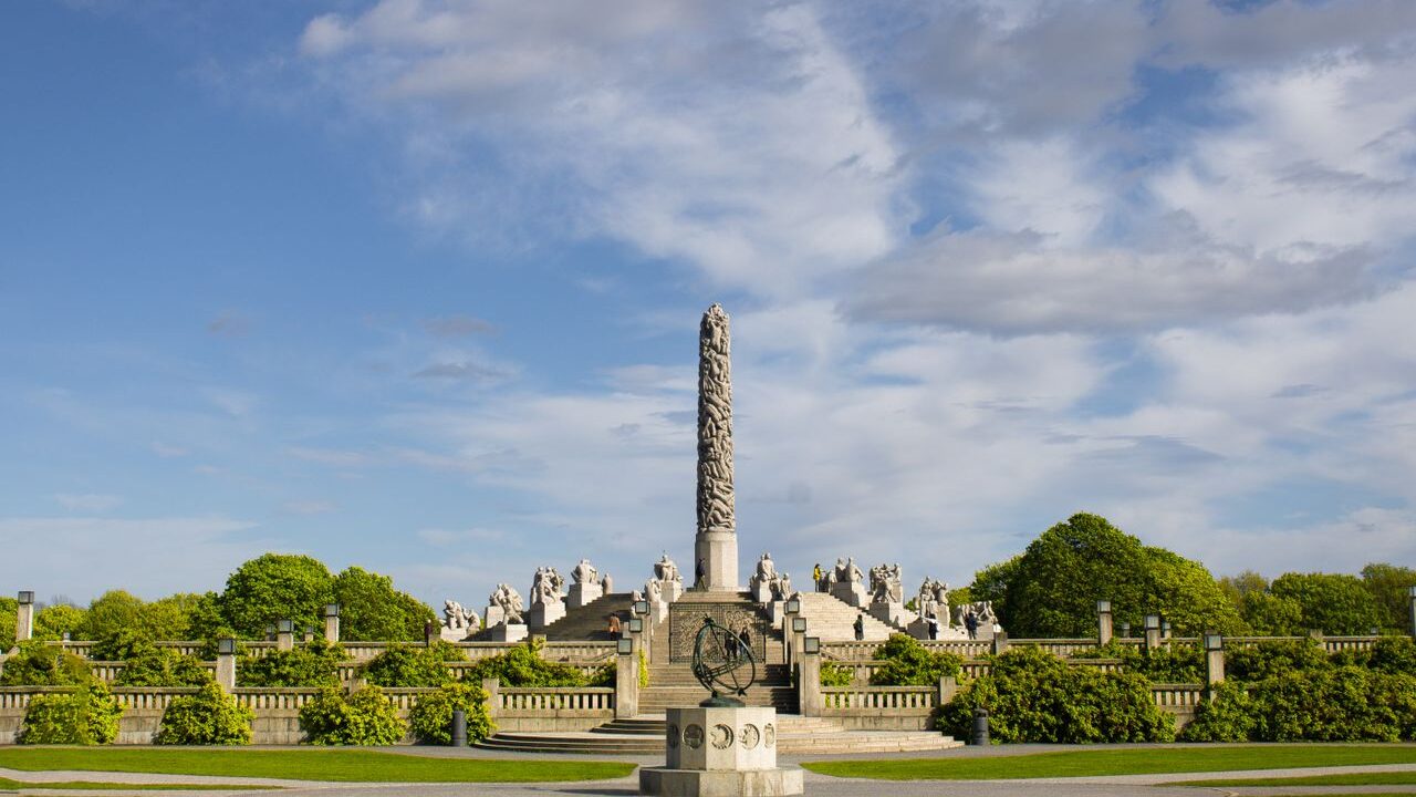 Vigeland's Monolith in Oslo's famous sculpture park against a bright blue sky.